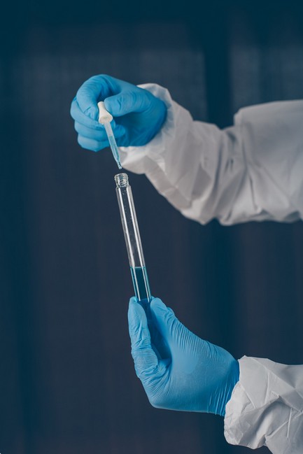 a person holding a tube with a dropper