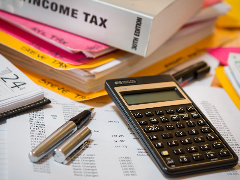 The Hidden Cost of Ambiguity: 5 Real-World Financial Translation Disasters. image showing calculator, pens and financial papers and books