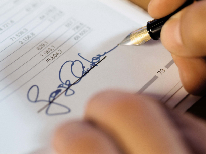 The Ultimate Guide to Mastering Global Legal Translation Services. an employee signinig a document
