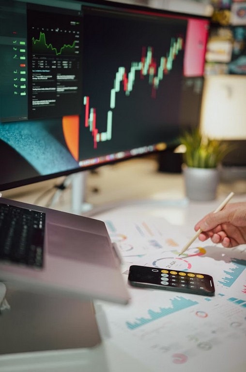 The Fintech & Blockchain Dictionary: What You Need to Know (And What They Won't Tell You). a worktable with smartphone and pc displaying financail data