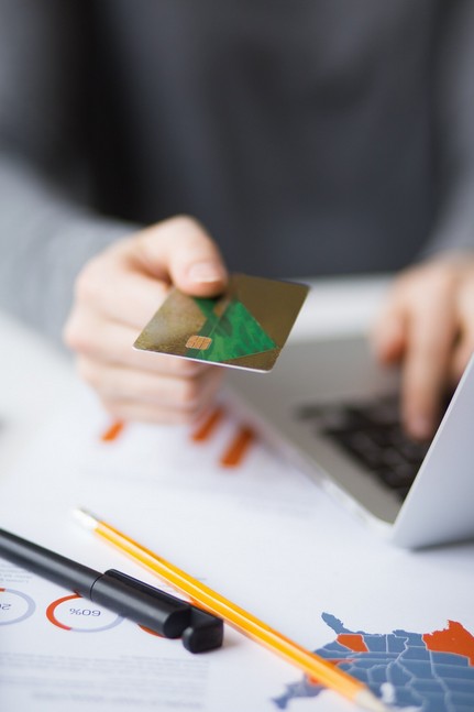Transcreation vs. Translation: The Ultimate Guide for Fintech Marketing. person holding credit card in the hand and pens and financail sheets on the table