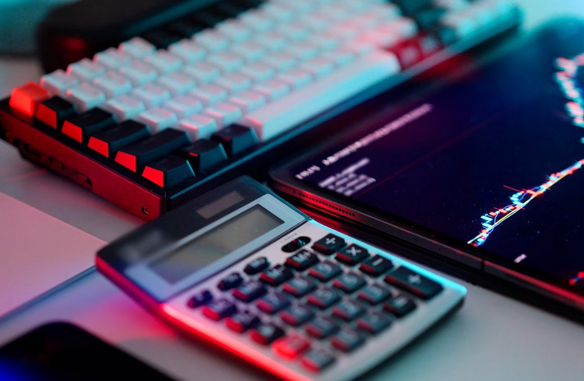 Unleash Asia: The Ultimate Guide to Fintech App Localization. calaculator, laptop and tablet displaying banking data