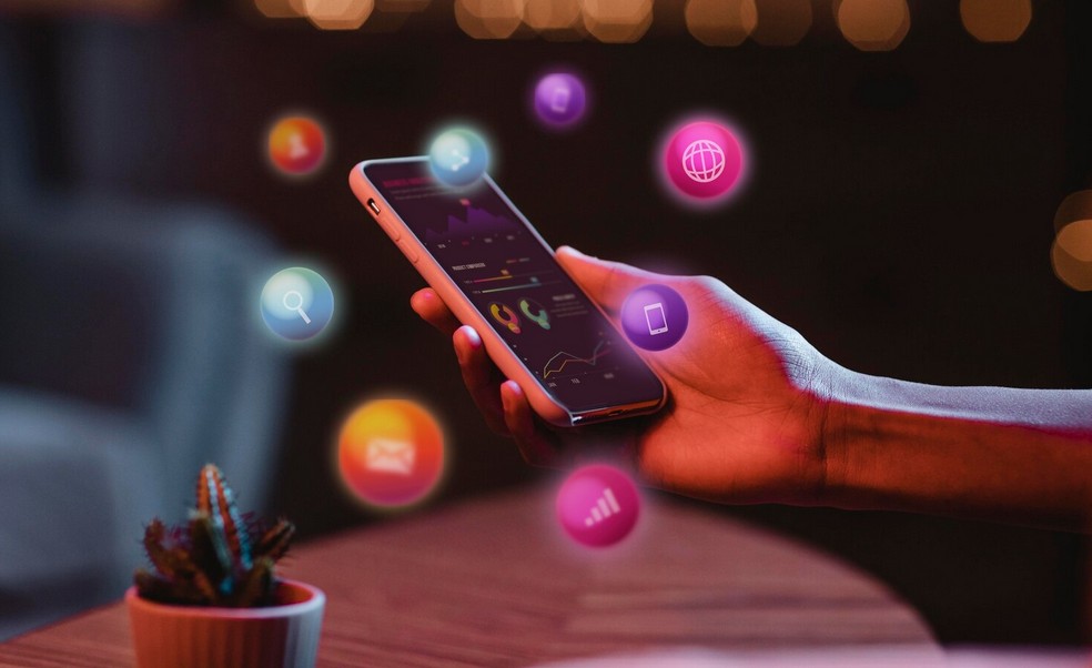 The Ultimate Guide to Winning New Markets with Retail Localization. a person holdling a smpartpohne in hand with communication icons