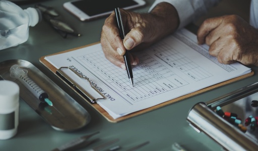 Eliminate Regulatory Risk: Secure Your Approval in the U.S., Europe, and Japan. a person writing on a medical sheet.