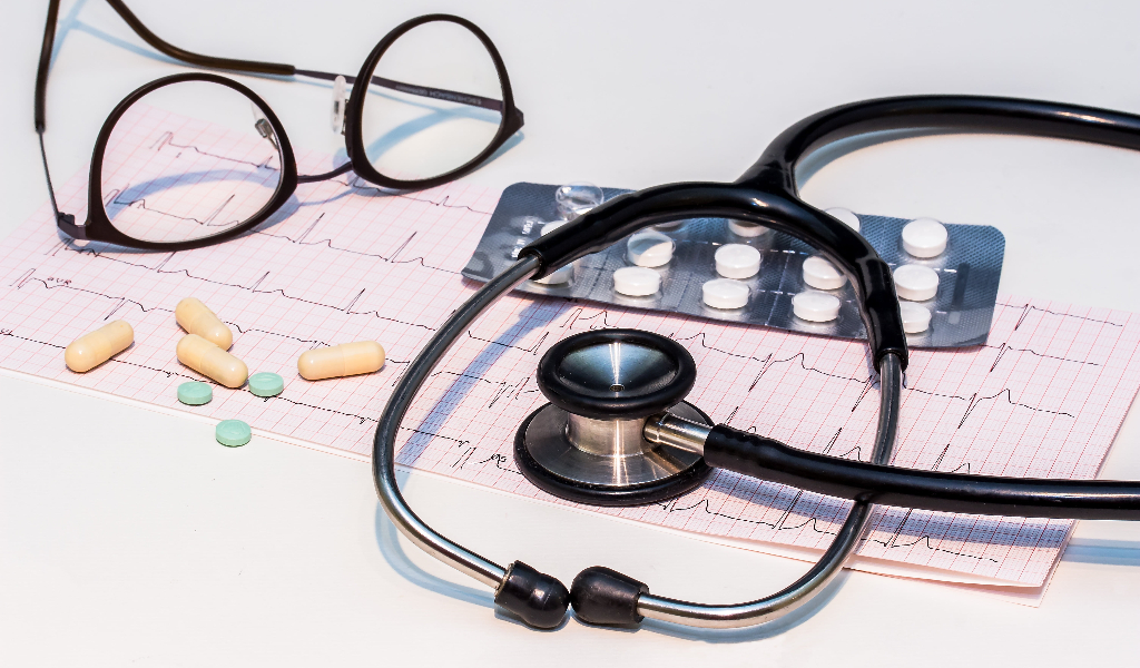 Eliminate Regulatory Risk: Secure Your Approval in the U.S., Europe, and Japan. image showing a stethoscope, orrective glasses, medical sheets and pills
