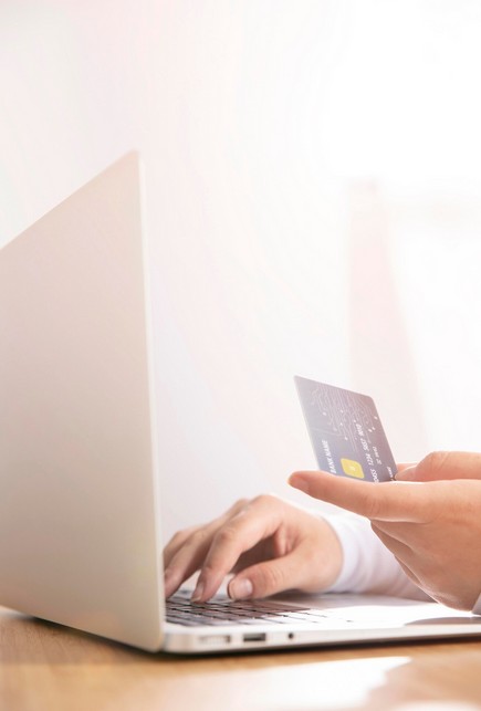 Unleash Asia: The Ultimate Guide to Fintech App Localization. a person making online purchase using a laptop and credit card