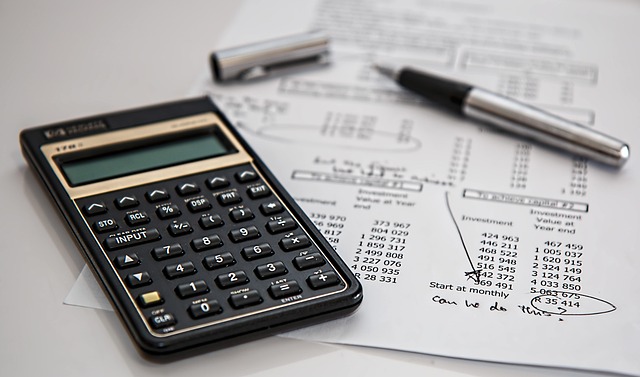 a calculator and a pen on financial sheets